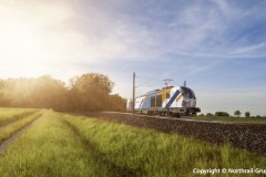 High-speed train moving through nature at sunset
