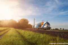 High-speed train moving through nature at sunset